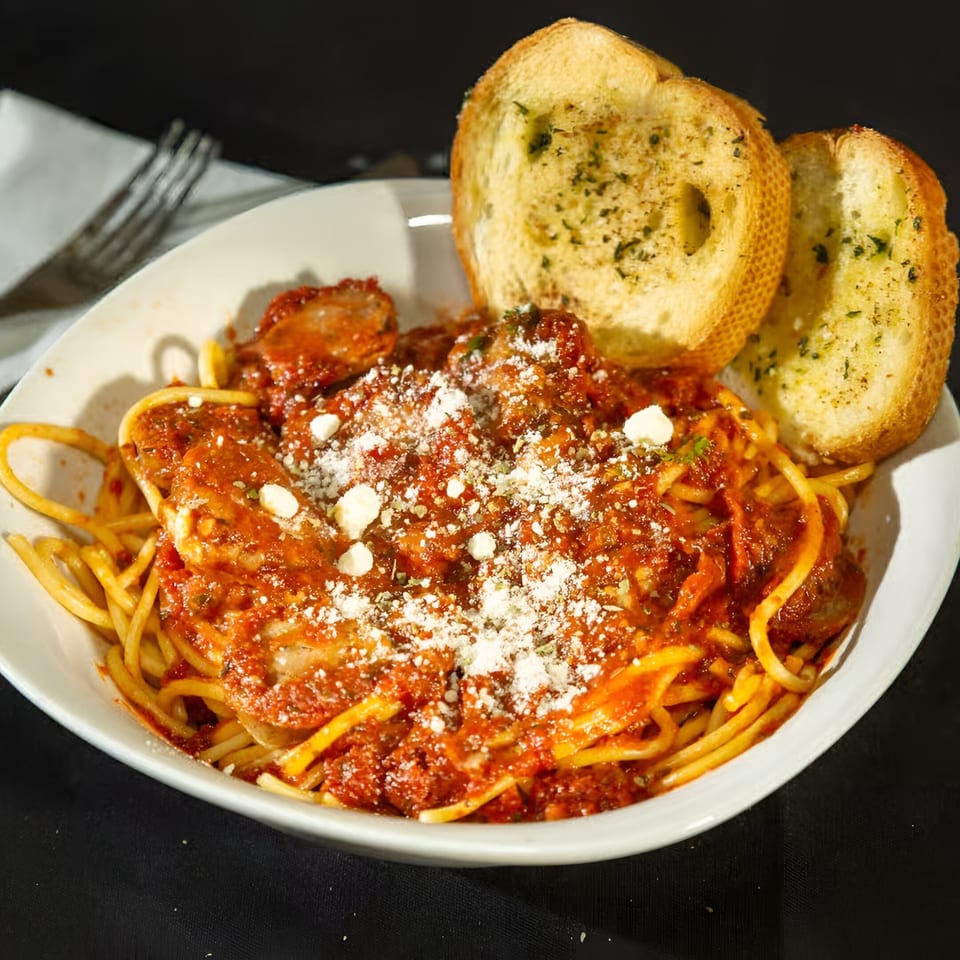 Monjunis Italian Cafe & Grocery's spaghetti with meatballs, red sauce, parmesan, and garlic bread.